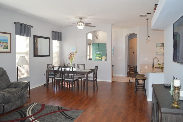 dining area with ceiling fan, dark hardwood / wood-style flooring, and sink