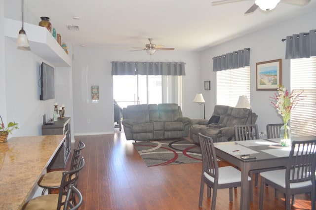 living room featuring ceiling fan, a healthy amount of sunlight, and dark hardwood / wood-style flooring