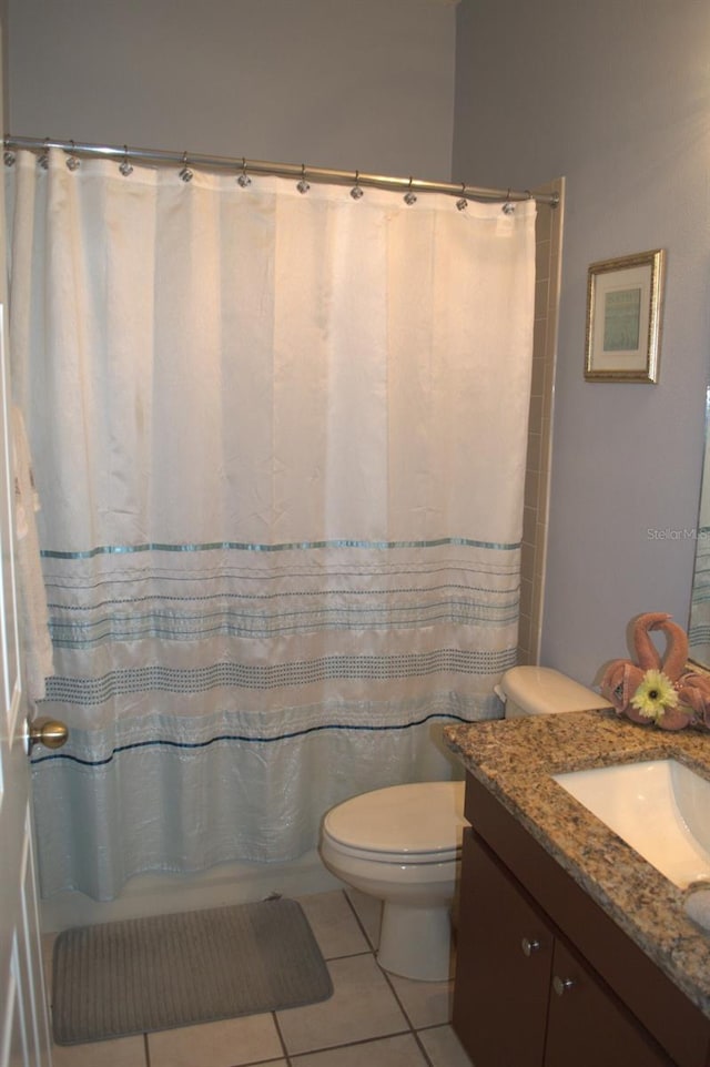 bathroom featuring a shower with shower curtain, vanity, toilet, and tile patterned flooring