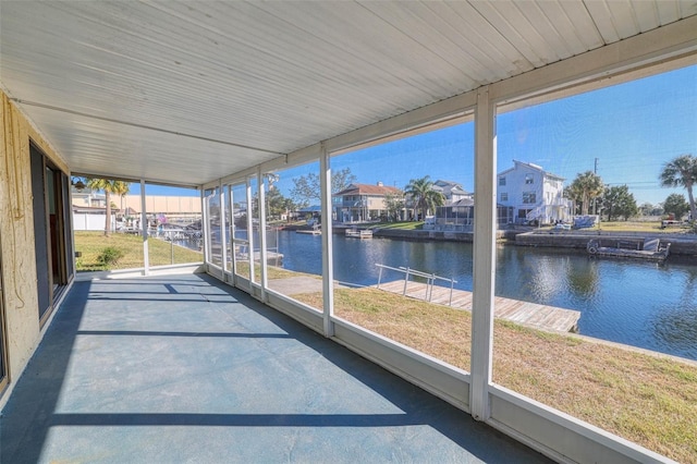 unfurnished sunroom featuring a water view