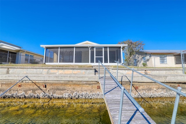 rear view of house with a water view and a sunroom