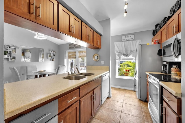 kitchen featuring a healthy amount of sunlight, appliances with stainless steel finishes, sink, and light tile patterned floors