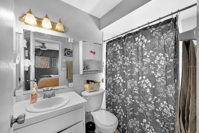 bathroom with toilet, a shower with curtain, vanity, ceiling fan, and decorative backsplash