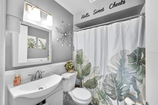 bathroom with vanity, a shower with shower curtain, and toilet