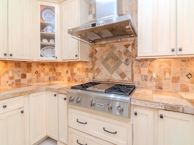 kitchen with tasteful backsplash, stainless steel gas stovetop, and extractor fan