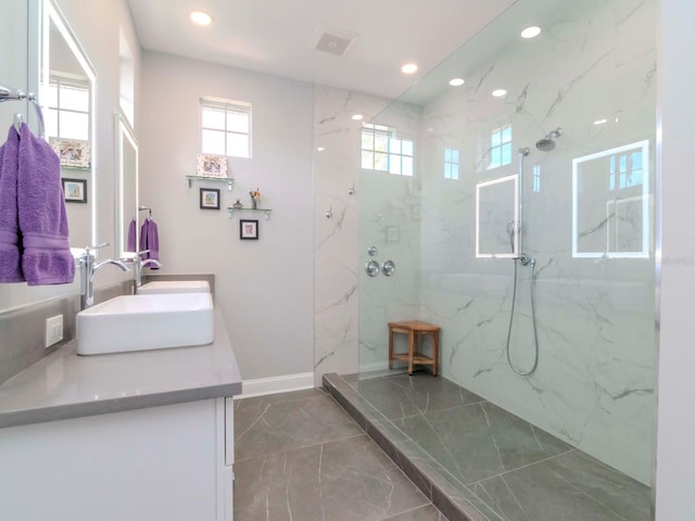 bathroom featuring tiled shower and vanity