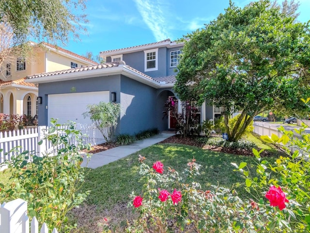 mediterranean / spanish home with a garage and a front lawn