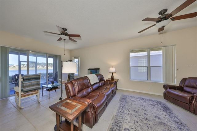 tiled living room featuring a water view and ceiling fan