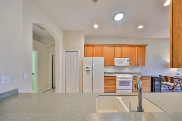 kitchen featuring sink, white appliances, and beverage cooler