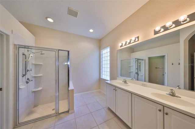 bathroom featuring tile patterned flooring, vanity, and a shower with door