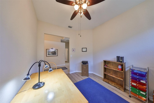 workout area featuring ceiling fan and light hardwood / wood-style floors