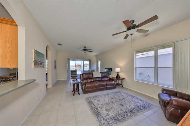 tiled living room featuring ceiling fan and a textured ceiling