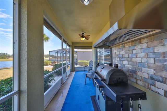 sunroom featuring plenty of natural light, ceiling fan, and a water view