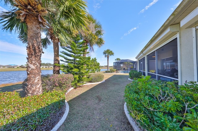 view of yard featuring a water view and glass enclosure