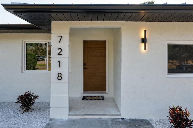 property entrance with stucco siding