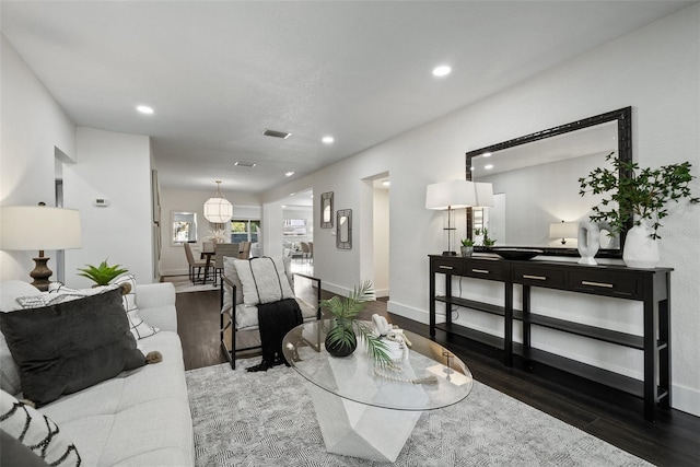 living room with visible vents, baseboards, wood finished floors, and recessed lighting