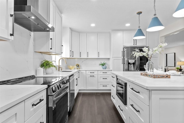 kitchen featuring dark wood-style floors, appliances with stainless steel finishes, white cabinets, a sink, and wall chimney range hood