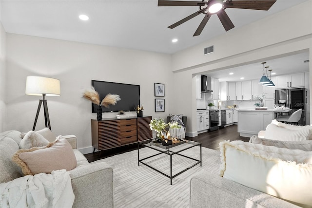 living area with dark wood-style floors, baseboards, visible vents, and recessed lighting