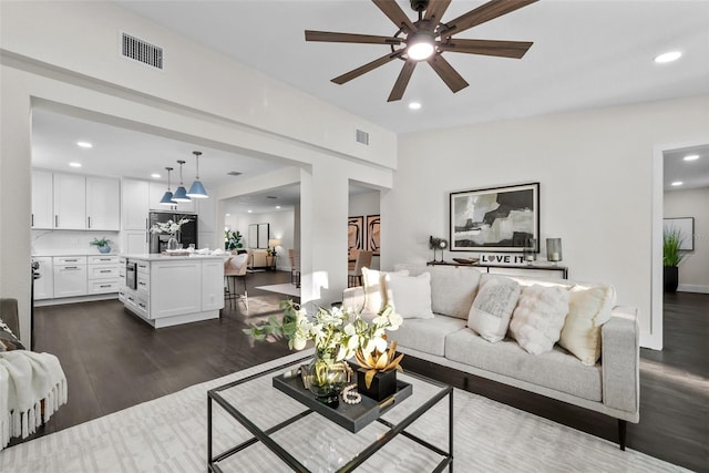 living area featuring ceiling fan, dark wood-style flooring, visible vents, and recessed lighting