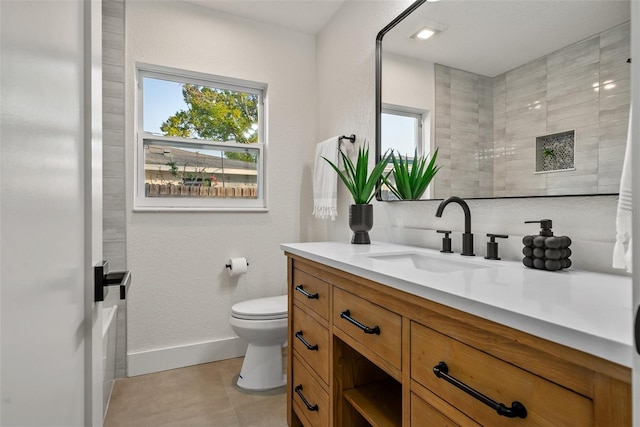 bathroom featuring baseboards, vanity, toilet, and tile patterned floors