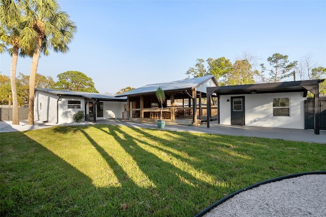 back of house with a yard, stucco siding, a patio, and fence