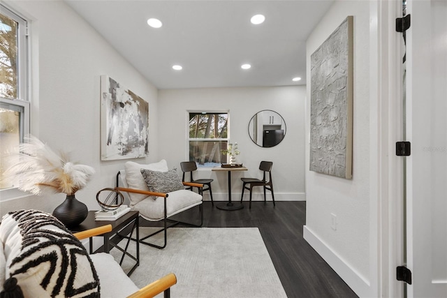 living area featuring recessed lighting, dark wood-style flooring, and baseboards