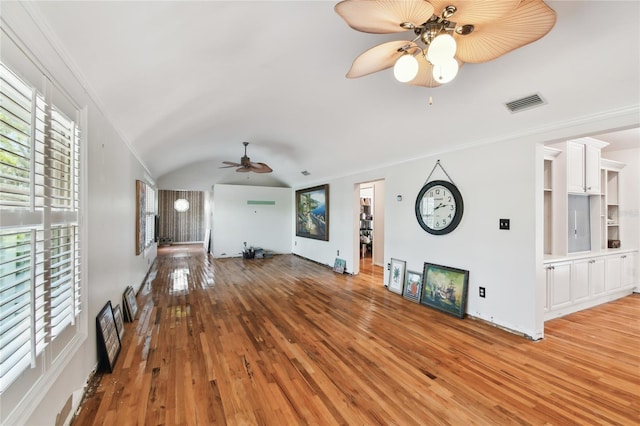 unfurnished living room featuring lofted ceiling, ornamental molding, light hardwood / wood-style floors, and ceiling fan