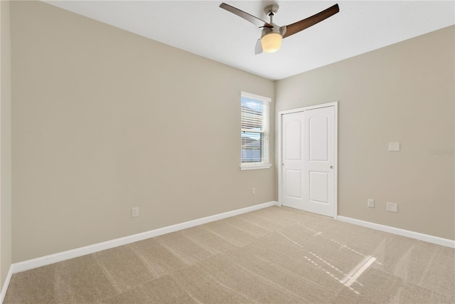 empty room featuring ceiling fan and light carpet