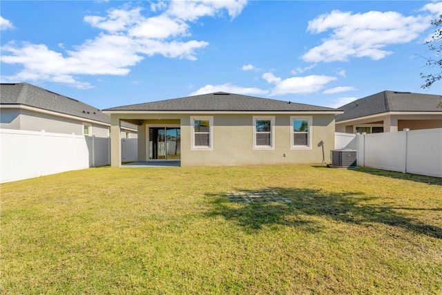 rear view of property featuring cooling unit, a lawn, and a patio