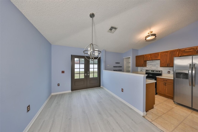 kitchen featuring lofted ceiling, hanging light fixtures, backsplash, stainless steel appliances, and kitchen peninsula