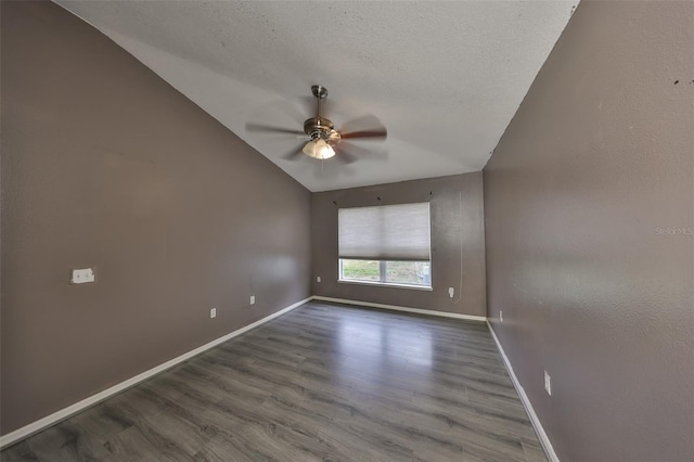 empty room featuring ceiling fan, hardwood / wood-style flooring, vaulted ceiling, and a textured ceiling