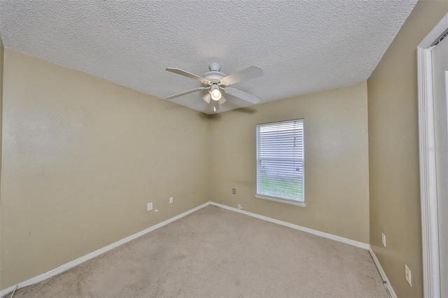 carpeted empty room featuring ceiling fan and a textured ceiling