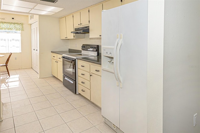 kitchen featuring cream cabinets, white fridge with ice dispenser, light tile patterned floors, and electric range