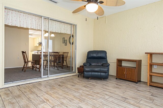 living area featuring ceiling fan and light hardwood / wood-style flooring