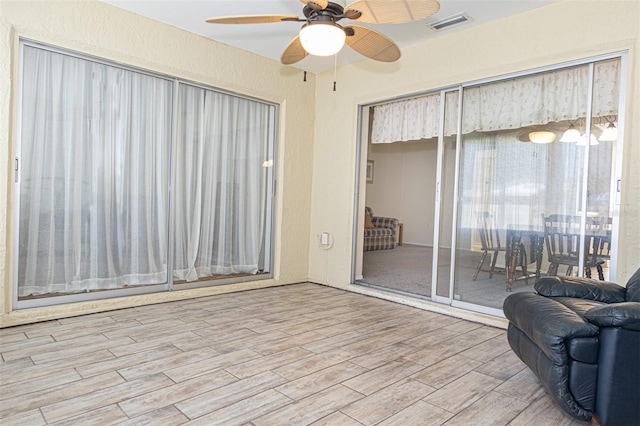 interior space with wood-type flooring and ceiling fan