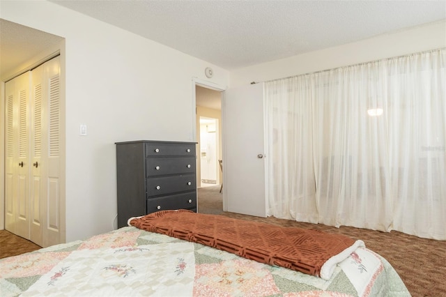 carpeted bedroom with a closet and a textured ceiling