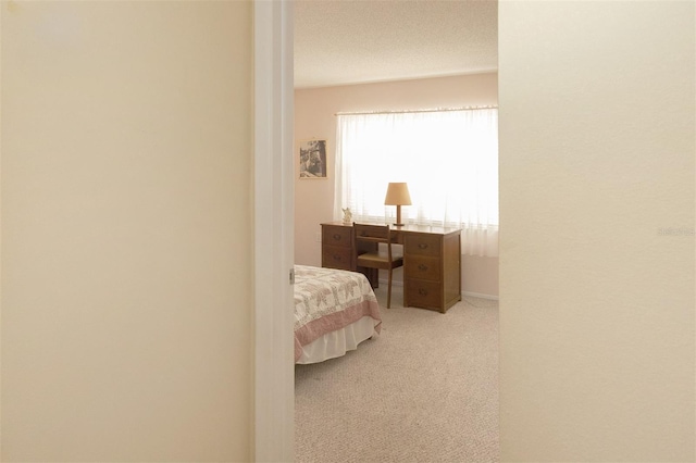 bedroom featuring light carpet and a textured ceiling