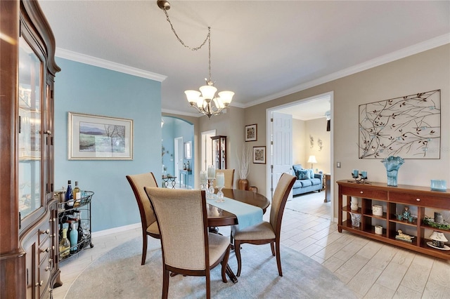 dining room with ornamental molding, a chandelier, and light wood-type flooring