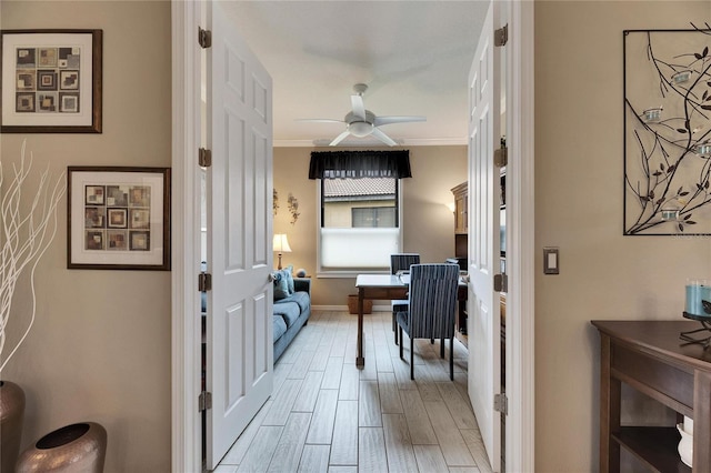 interior space with ornamental molding, light wood-type flooring, and ceiling fan