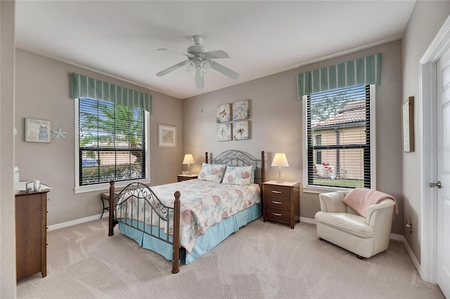 bedroom with light carpet, multiple windows, and ceiling fan