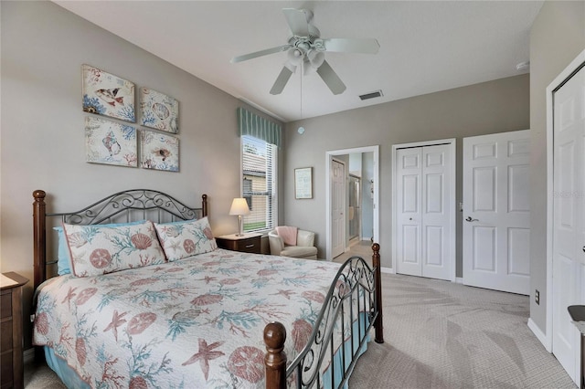 bedroom featuring ceiling fan, light colored carpet, ensuite bath, and a closet