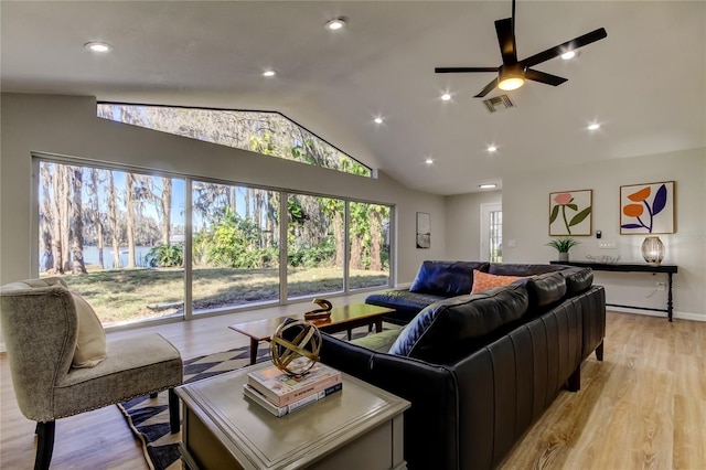 living room with vaulted ceiling, plenty of natural light, ceiling fan, and light hardwood / wood-style floors