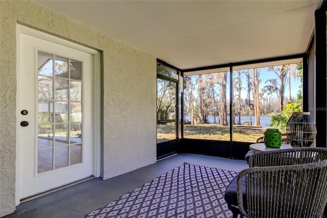 sunroom featuring a water view