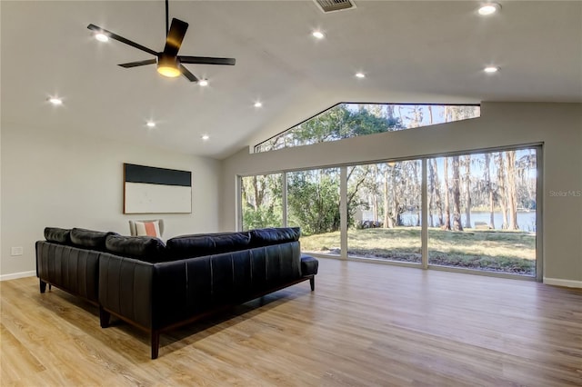 living room with light wood-type flooring, vaulted ceiling, and ceiling fan