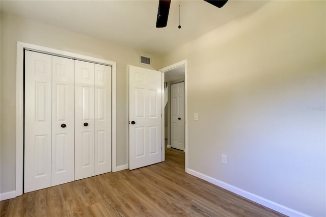 unfurnished bedroom with a closet, ceiling fan, and wood-type flooring