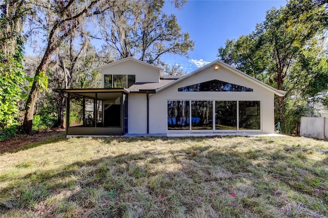 rear view of property with a sunroom and a lawn