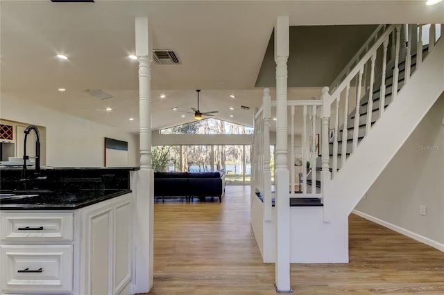 kitchen with decorative columns, sink, ceiling fan, dark stone countertops, and white cabinets