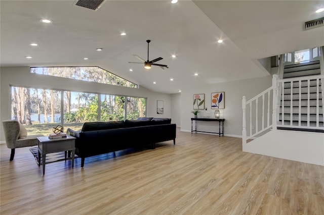 living room with light hardwood / wood-style floors, lofted ceiling, and ceiling fan