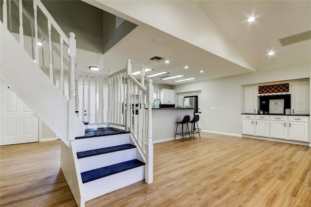 staircase featuring hardwood / wood-style flooring and vaulted ceiling