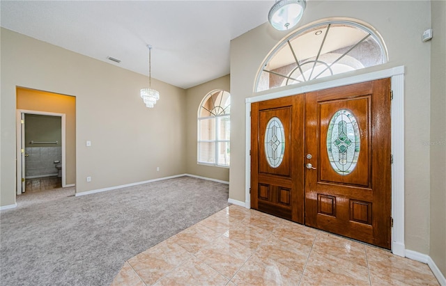 entrance foyer featuring an inviting chandelier and light colored carpet